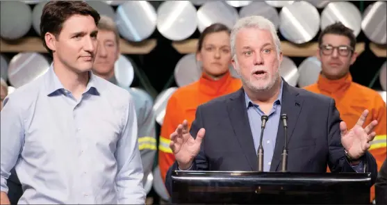  ?? The Canadian Press ?? Prime Minister Justin Trudeau, left, looks on as Quebec Premier Philippe Couillard speaks to workers and reporters at a news conference during a visit of the Rio Tinto AP60 aluminum plant Monday in Saguenay Que.