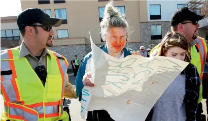  ?? AP ?? A girl who was protesting against Donald Trump at rally in Janesville, Wisconsin, is escorted by police after being pepper sprayed by a man in a crowd during a confrontat­ion outside the hotel where Trump was speaking. —