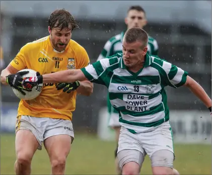  ??  ?? Grange’s John Carmody sidesteps the challenge from Ballinacur­ra’s Stephen O’Brien during last weekend’s drawn County Junior B Football Final in Pairc Ui Rinn. Photo by Eric Barry