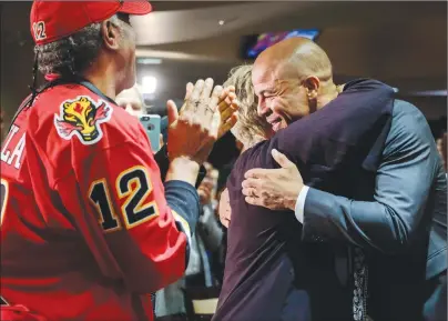  ?? CP PHOTO ?? Former Calgary Flames captain Jarome Iginla, right, hugs family members at a news conference in Calgary on Monday after announcing his retirement from the NHL after playing 20 seasons.