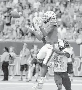  ?? MICHAEL LAUGHLIN/SUN SENTINEL ?? Hurricanes receiver K.J. Osborn catches a touchdown pass in front of Bethune -Cookman’s Sam Marc during the first half of Saturday’s game in Maimi Gardens.