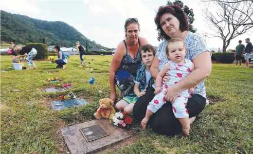  ?? Picture: STEWART McLEAN ?? HEARTBREAK­ING: Trudy Eldridge, Jacob Downing, 9, Natasha Downing and Mia Cawwood, 13 months, lay flowers and clean up the grave of Natasha's daughter Cheyenne Downing.