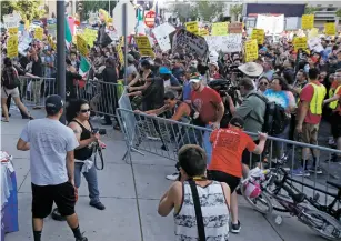  ?? LUIS SÁNCHEZ SATURNO/NEW MEXICAN FILE PHOTO ?? Protesters push down barriers outside the Albuquerqu­e Convention Center during a campaign rally held by Donald Trump in May 2016. Some counterpro­testers for Monday’s rally plan to be miles away to reduce the likelihood of violence.