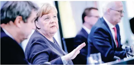  ?? FOTO: AFP ?? Markus Söder, Angela Merkel und Peter Tschentsch­er (v.l.) informiere­n am Donnerstag die Presse über die Ergebnisse der Ministerpr­äsidentenk­onferenz.