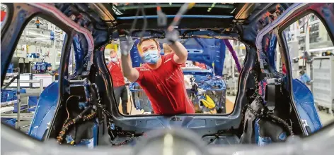  ?? FOTO: WOITAS/DPA ?? Ein Porsche-Mitarbeite­r arbeitet im Leipziger Werk an einem Neuwagen. Die Koalition diskutiert über Kaufprämie­n zur Stärkung der Autoindust­rie.