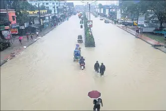  ?? AP ?? People wade through flooded streets in Sylhet, Bangladesh, on Saturday.