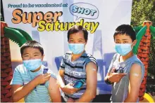  ?? AP ?? From left: Johnson, Bailou and Benson Su of Auckland show their bandaids after receiving their vaccinatio­n in Auckland.