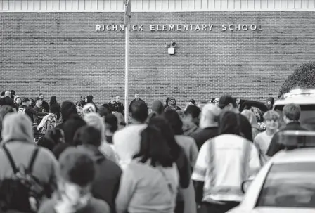  ?? Billy Schuerman/Associated Press ?? Students and police gather outside of Richneck Elementary School after a shooting Friday in Newport News, Va., sent a first-grade teacher to the hospital and ended with “an individual” in custody, officials said.