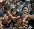  ??  ?? Desperate Rohingya refugees reach for handouts of clothing and food at an aid centre in Tankhali, Bangladesh.