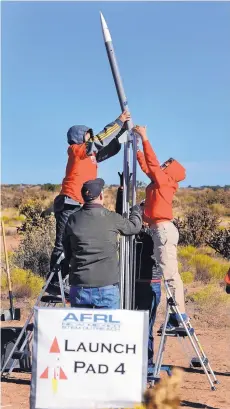  ?? JIM THOMPSON/JOURNAL ?? Aiden Sanchez, left, and Soren Briggs, from Menaul School, load their rocket onto a launchpad for the Air Force Research Laboratory STEM Academy’s rocket launch Tuesday in Rio Rancho.