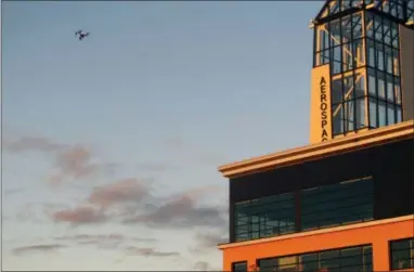  ?? THE ASSOCIATED PRESS ?? A drone being flown by University of North Dakota students hovers over an aerospace building in Grand Forks, North Dakota, on Sept. 28. The flying session was part of the school’s first drone business class that is meant to show students what it will...