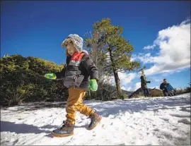  ?? Francine Orr Los Angeles Times ?? ISAAC RIVERA, 3, of Covina frolics in the snow in the Angeles National Forest on Christmas Eve. A winter storm warning will be in effect until 10 p.m. Thursday.