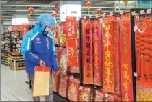  ?? PROVIDED TO CHINA DAILY ?? A courier for online delivery company Eleme picks up couplets for a client at a Shanghai supermarke­t before Spring Festival.