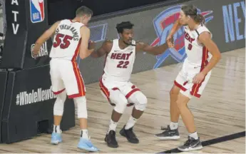  ?? KEVIN C. COX/GETTY IMAGES ?? The Heat’s Jimmy Butler gets a hand from his teammates Saturday against the Nuggets.