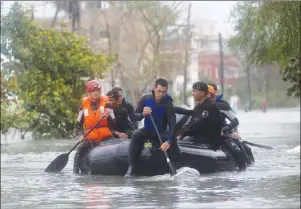  ?? AP PHOTO ?? Members of a rescue team navigate a flooded street in Havana after the passage of Hurricane Irma in Cuba on Sunday. The powerful storm ripped roofs off houses, collapsed buildings and flooded hundreds of miles of coastline after cutting a trail of...