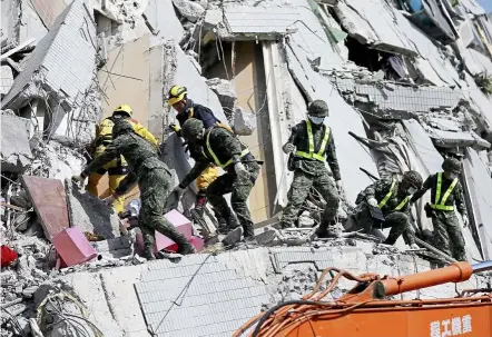  ?? — EPA ?? Ongoing efforts: Taiwan rescuers searching for survivors at a collapsed building in Tainan, southern Taiwan.
