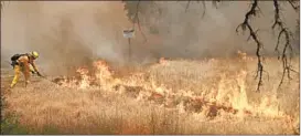  ?? MARCIO JOSE SANCHEZ/AP ?? A firefighte­r takes a rake to flames Monday as a wildfire advances in Lakeport, Calif.