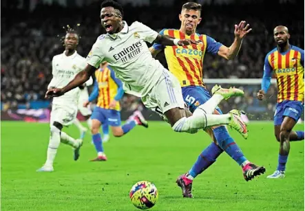  ?? — AFP ?? Not cool: real Madrid’s Vinicius Junior (front) is fouled by Valencia’s Gabriel Paulista during the La Liga match at the bernabeu.