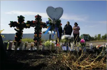  ?? ERIC GAY — THE ASSOCIATED PRESS ?? Mourners pay their respects at a makeshift memorial at the site where officials found dozens of people dead in an abandoned semitraile­r containing suspected migrants June 29 in San Antonio.