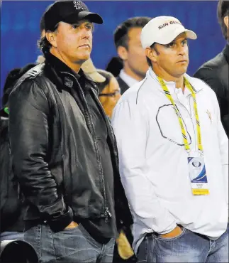  ?? Matt York ?? The Associated Press file Phil Mickelson, left, and his brother, Tim Mickelson, watch the Pac-12 championsh­ip football game in Tempe, Ariz., in December. Phil will have Tim on his bag starting Thursday at the Greenbrier Classic.