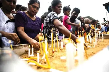  ??  ?? Christian devotees light candles as they pray at a barricade near St. Anthony’s Shrine in Colombo a week after a series of bomb blasts targeting churches and luxury hotels on Easter Sunday in Sri Lanka. — AFP photo
