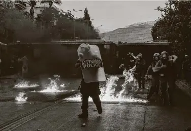  ?? Petros Giannakour­is / Associated Press ?? Riot police try to avoid gasoline bombs thrown by protesters in Athens during a demonstrat­ion against a new law to curb public protests. Six police officers were injured, and nine people were arrested.