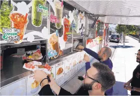  ?? AMIAN DOVARGANES/ASSOCIATED PRESS ?? Customers get their lunch at the Japanese food truck Okamoto Kitchen in Beverly Hills, Calif. It serves nontraditi­onal offerings using traditiona­l Japanese flavors.