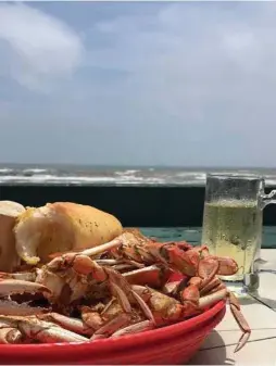  ??  ?? Benno’s on the Beach serves feasts of whole crabs and crawfish, just beyond Galveston’s notorious seawall and crashing waves.