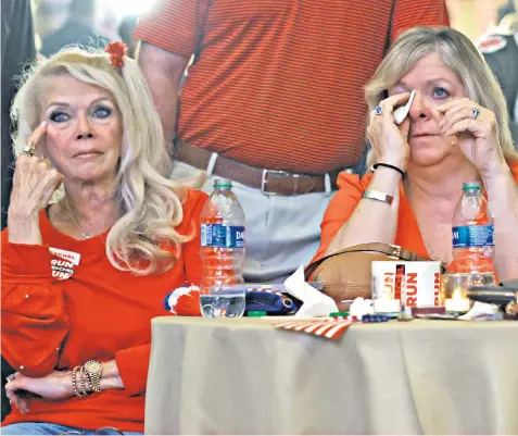  ?? ?? Supporters of Herschel Walker, the Republican Senate candidate, wipe away tears after he lost the midterm election runoff election to Democrat Raphael Warnock