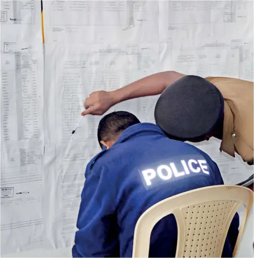  ??  ?? Two Policemen collect informatio­n of candidates from a humungous nomination­s list pasted outside an office in Nuwara Eliya where nomination­s for the Local Government elections were accepted on Thursday. Pix by Shelton Hettiarach­chi.