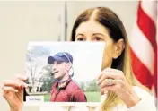  ?? AMY BETH BENNETT South Florida Sun Sentinel ?? Linda Beigel Schulman holds a photograph of her son, victim Scott Beigel, a geography teacher and cross country coach, during the penalty phase of the trial.