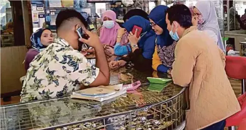  ??  ?? PENURUNAN harga emas membuatkan orang ramai ‘menyerbu’ kedai emas untuk membuat pelaburan.