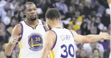  ?? Carlos Avila Gonzalez / The Chronicle ?? Stephen Curry congratula­tes Kevin Durant for a three-pointer during the first half of the Warriors’ win over the Lakers.