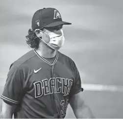  ??  ?? Diamondbac­ks pitcher Robbie Ray wears a mask at summer camp workouts at Chase Field.