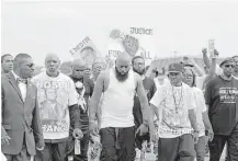  ?? Jeff Roberson / Associated Press ?? Michael Brown Sr., center, takes part in a parade on Saturday in honor of his son, Michael, in Ferguson, Mo. Sunday will mark one year since Michael was shot and killed by Ferguson police.