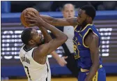  ?? JEFF CHIU — THE ASSOCIATED PRESS, FILE ?? Nets forward Kevin Durant, left, shoots against Warriors forward Andrew Wiggins during the first half on Feb. 13 in San Francisco.