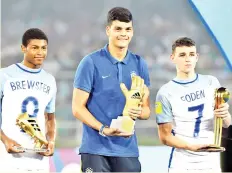  ??  ?? England’s midfielder Phil Foden (R) with his ‘Man of the Tournament’ trophy, England’s forward Rhin Brewster (L) with his ‘Highest Scorer’ trophy and England’s Brazilian goalkeeper Gabriel Brazao with his ‘Best Goalkeeper’ trophy pose for a photo after...