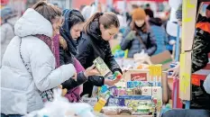  ?? PETER LAZAR
AFP ?? UKRAINIAN refugees take free food and drinks in Vysne Nemecke, Slovakia. Streams of people in cars and on foot were seen crossing into Hungary, Poland and Romania. |