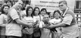  ??  ?? TMC VP for Ops., Engr. Aloysius C. Diaz, hands a rooster to DAPJA President Eddie Gasulas while TMC Resident Mine Manager, Engr. Jun Valeroso holds a native hen. Also in the photo (extreme left) is TMC Community Relations Manager, Roel Paniza, and other members of DAPJA Native Chicken Poultry Farm.