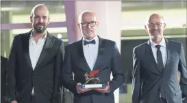  ??  ?? Disney’s marketing director for Italy, Davide Romani, center, holds the Golden Lion Best Film award for “Nomadland” at the closing ceremony of 77th edition of the Venice Film Festival.