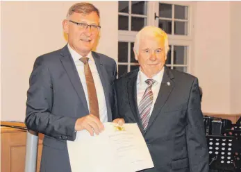  ?? FOTO: KORNELIA HÖRBURGER ?? Oberbürger­meister Michael Beck (links) überreicht im Auftrag des Ministerpr­äsidenten die Landesehre­nnadel an Hans Sieger aus Möhringen.
