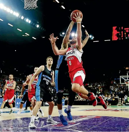  ?? PHOTOS: GETTY IMAGES ?? Mitch Norton of the Hawks goes up against DJ Newbill of the Breakers during their their NBL clash in Auckland yesterday.