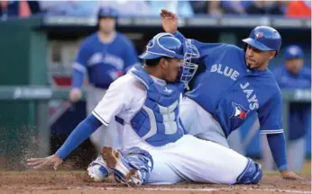  ?? JOHN SLEEZER/MCT ?? Blue Jay Maicer Izturis, right, slides safely home ahead of the tag from K.C. catcher Salvador Perez on Saturday.