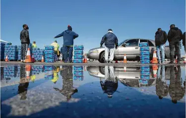  ?? Yi-Chin Lee / Staff photograph­er ?? Texas Southern University volunteers give out free bottled water at a mass distributi­on Friday at Delmar Stadium.