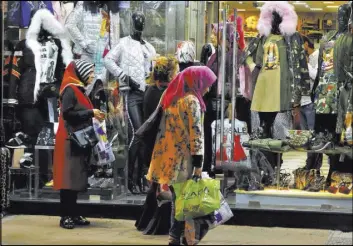  ?? Bilal Hussein The Associated Press ?? Tourists from Iraq window-shop in front of a store on Friday in Beirut, Lebanon. Prime Minister Saad Hariri’s shock resignatio­n could derail the first steps in years toward kick-starting Lebanon’s anemic economy.