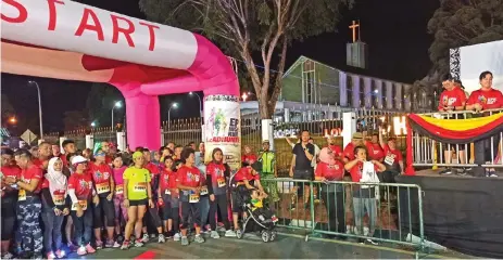  ??  ?? Sharzede (second right) presses an airhorn to flag off the 5km runners.