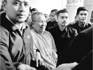  ?? — Bernama photo ?? MACC personnel escorting Mohd Isa to the court.