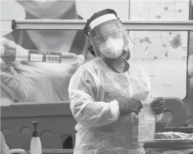  ?? LYNNE SLADKY/AP ?? A health care employee works at a COVID-19 testing site at Crandon Park in Miami. President-elect Joe Biden’s COVID-19 advisory board includes no nurses despite their essential role in the nation’s pandemic response.