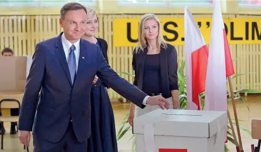  ?? (Reuters) ?? In famiglia Il nazionalpo­pulista Andrzej Duda, 43 anni, con la moglie Agata e la figlia Kinga. Secondo gli exit poll, ha battuto il presidente Komorowski