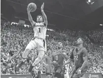  ??  ?? Kansas guard Devon Dotson goes to the basket past Texas Tech’s Kyler Edwards, center, and TJ Holyfield on Saturday. JAY BIGGERSTAF­F /USA TODAY SPORTS